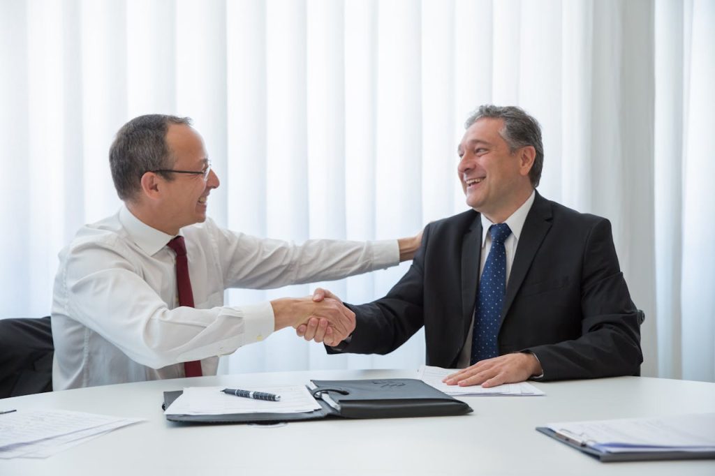 Men Looking at Each Other while Doing Hand Shake