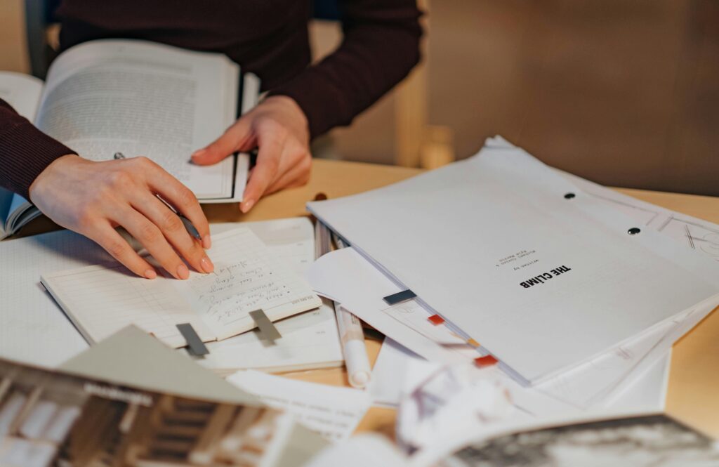 A Person Writing on a Notebook